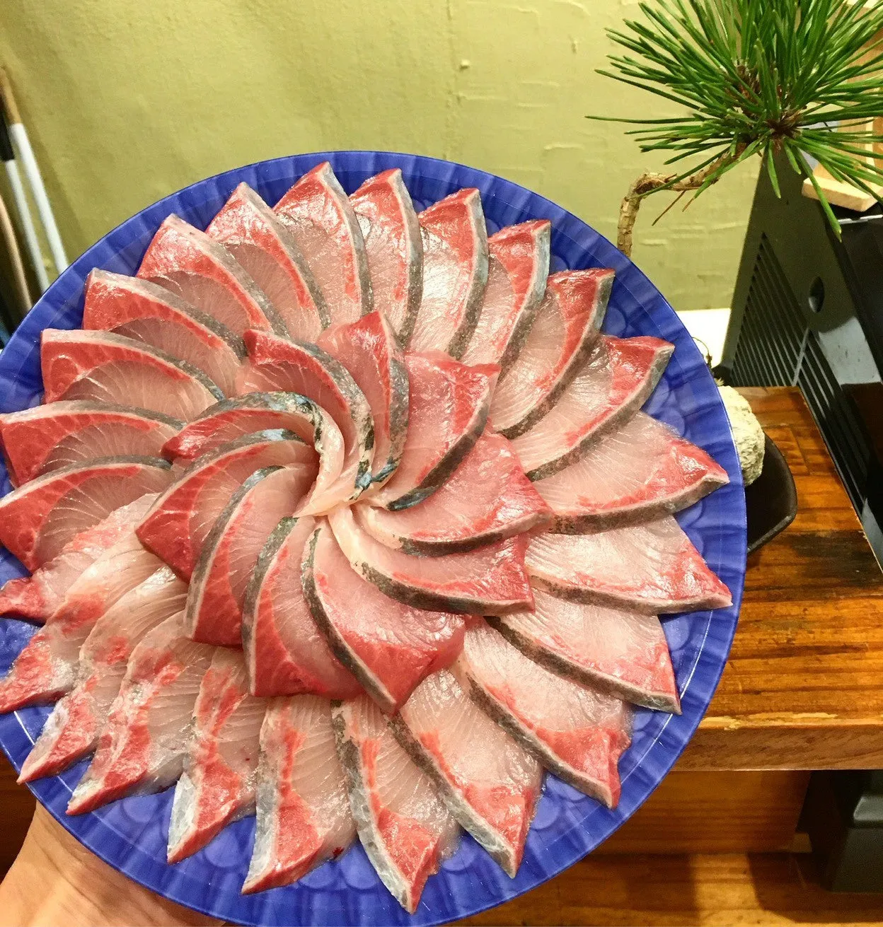 新鮮なハマチの刺身を花のように美しく盛り付けた一皿