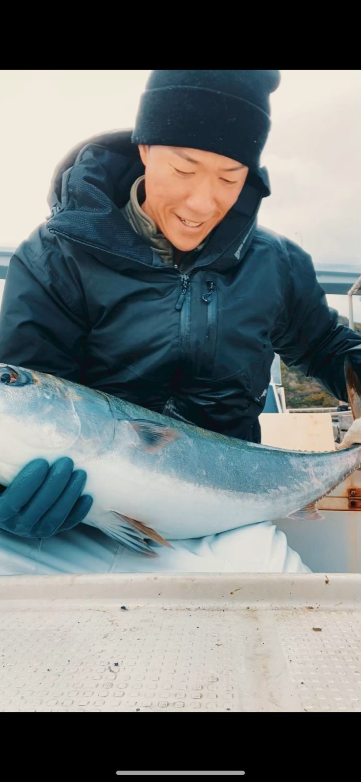 鳴門海峡で水揚げした魚を抱える漁師・西上大貴