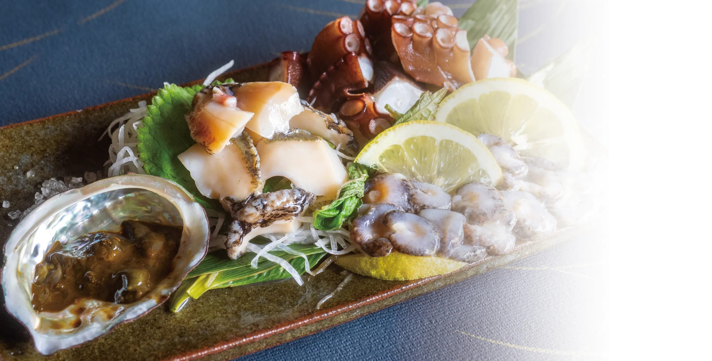 鮑やタコなど新鮮な魚介類を美しく盛り付けた料理